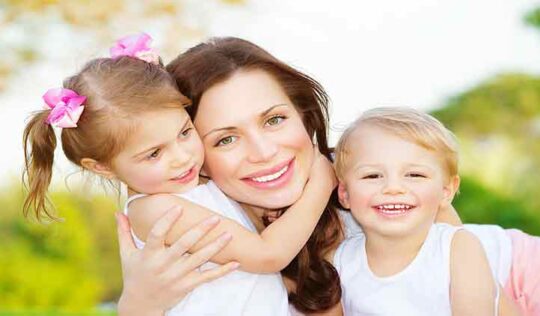Mother smiling with young children