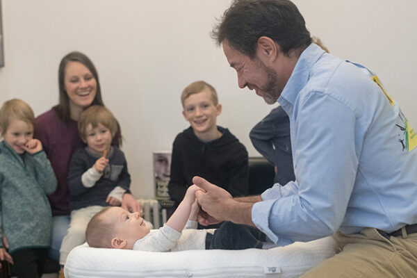 Dr Rubinstein adjusting a child with the family in the room at 57th St. Chiropractic in New York City.