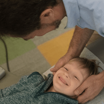 Young, smiling boy receiving a chiropractic adjustment from Dr Gregg Rubinstein at 57th Street Chiropractic in Manhattan.